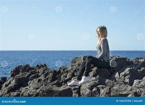 Junge Blonde Kaukasische Frau In Einem Neutralen Outfit Gekleidet In Einer Entspannenden