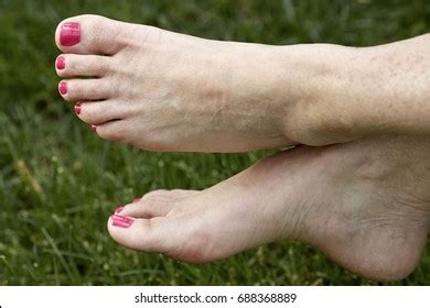 womans barefeet crossed ankles green grass stock photo