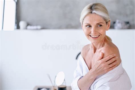 Smiling Senior Woman In Bathrobe Touching Her Naked Shoulder Stock Image Image Of Morning