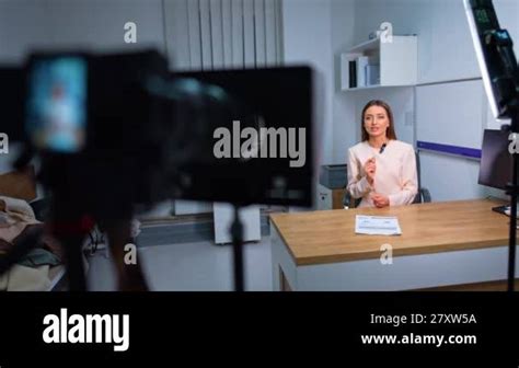 Beautiful Brunette Woman In White Jacket Speaks To Camera Recording Video By A Professional