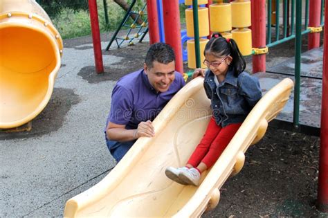 Dad With His Brunette Latina Daughter Play In The Park In The Games