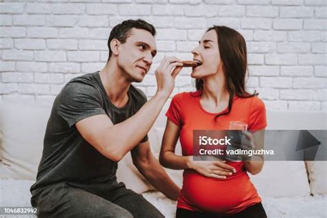 Husband And Pregnant Wife Eat Cookies Together Stock Photo - Download