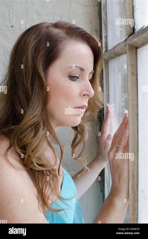 Sad Mature Woman Standing By The Window Stock Photo Alamy