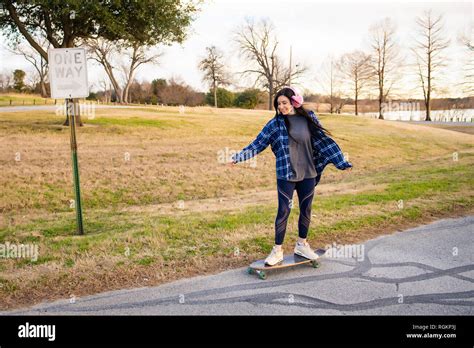 Image Of A Brunette Girl Riding A Skateboard And Enjoying It Stock Photo Alamy