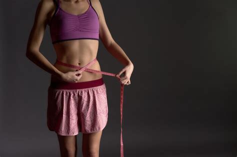 Premium Photo Sporty Woman With Tape Measure Measuring Her Waist Operation Bikini On Dramatic