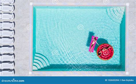 Dos Chicas Sexys En Bikini Nadan En Una Piscina Con Colchones Inflables Foto De Archivo Imagen
