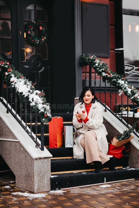 Beautiful Brunette Eats Chocolate On The Stairs With Shopping Winter