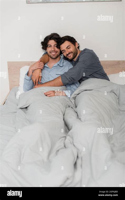 Couple Gay Souriant Et Accueillant Au Lit Photo Stock Alamy