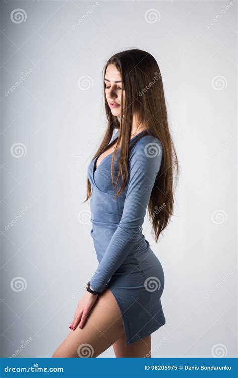 Una Ragazza Si Siede Su Un Cubo Ha Messo Le Sue Mani Sulle Sue Ginocchia Nude In Un Maglione