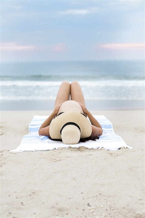 Schwangere Frau Mit Bikini Und Sonnenhut Am Strand Liegend Lizenzfreies Stockfoto