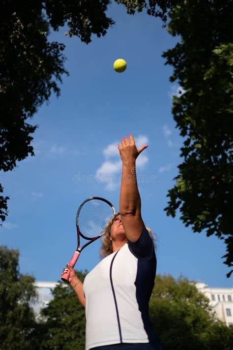 Mature Woman Playing Tennis Serving A Ball Outside Stock Image Image Of Athlete Activity