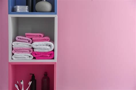 Premium Photo Stacks Of Clean Towels On Shelf Against Color Background