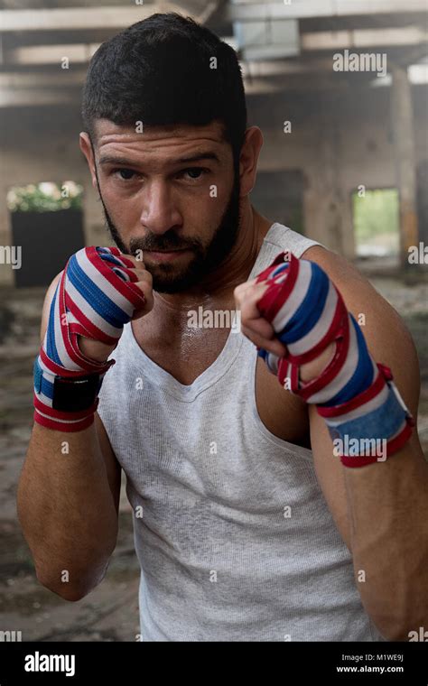 Portrait Of Muscular Male Boxer Posing In Boxing Stance Inside