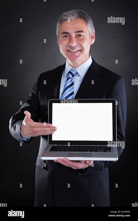Happy Mature Businessman Showing Laptop Over Black Background Stock Photo Alamy