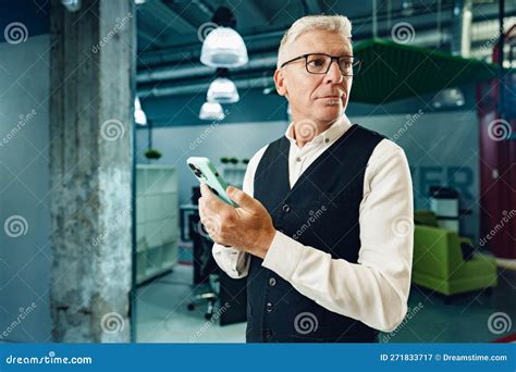 Handsome Mature Businessman Using His Mobile Phone In The Office Stock
