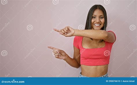 Jovem Latina Sorrindo Apontando Para O Lado Dedos Sobre Fundo Rosa Isolado Foto De Stock
