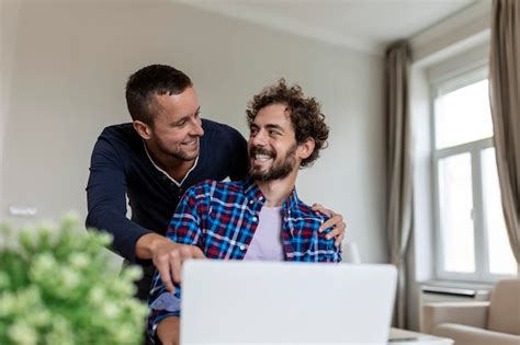 Lindo Casal Gay Rindo Juntos Enquanto Est Sentado Em Sua Sala De Estar Em Casa Dois Rom Nticos