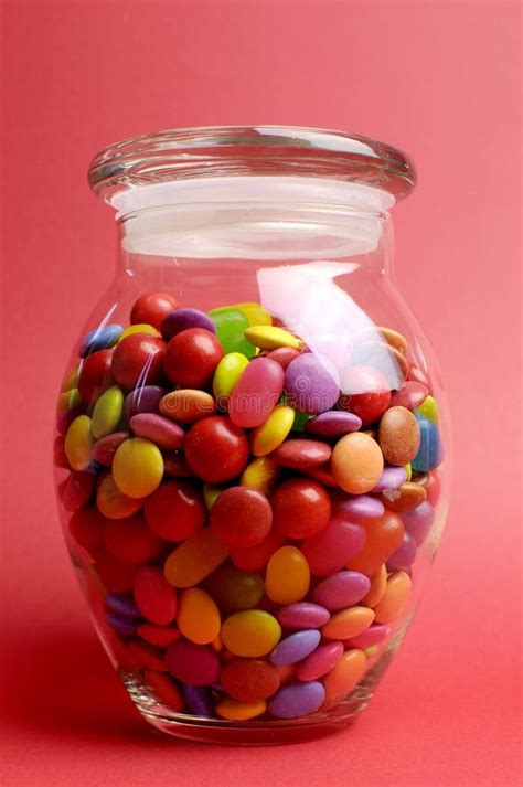 Glass Jar Full Of Bright Colorful Lollies And Candy With Closed Lid