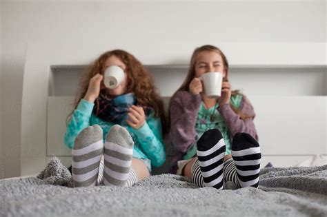 Friends Having Hot Chocolate On A Bed By Stocksy Contributor Skye Torossian Stocksy