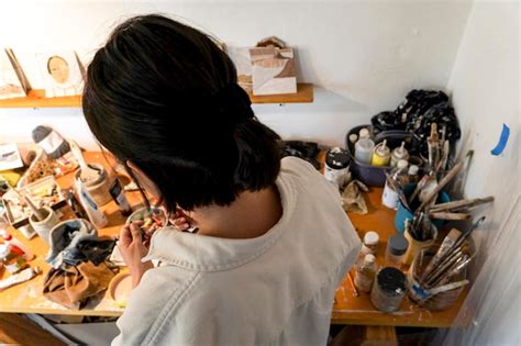 Jovem latina em seu próprio estúdio de pintura cria pinturas diferentes técnicas artísticas