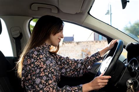 Jovencita De Brunette Segura Y Feliz Conduciendo En Auto Imagen De
