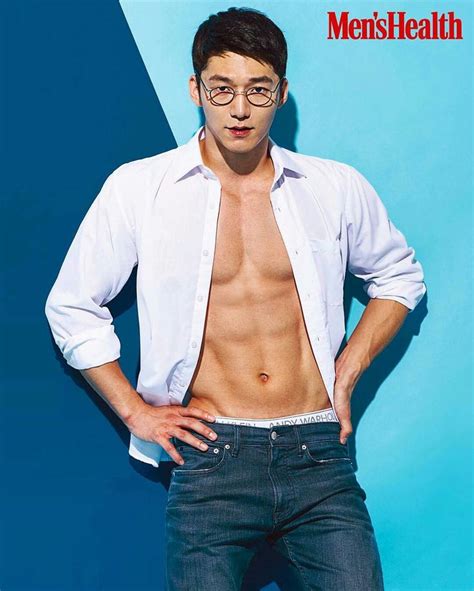 A Shirtless Man With Glasses Standing In Front Of A Blue Background