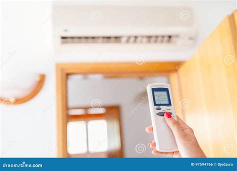 Close Up On Hand Adjusting Temperature Of Home Air Conditioner Stock