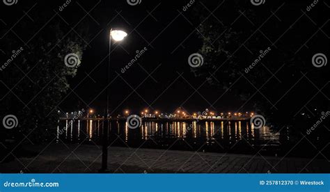 Calm Summer Night In The Park With A Lit Lamp Post At A Lake And An