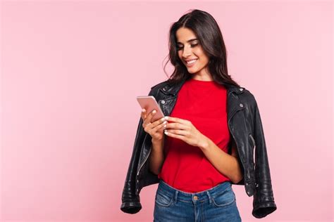 Free Photo Image Of Smiling Brunette Woman Using Smartphone Over Pink