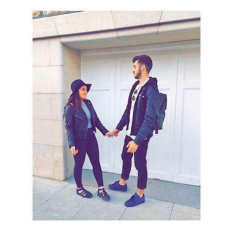 A Man And Woman Holding Hands In Front Of A Garage Door