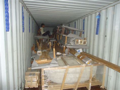 a man is sitting in the back of a shipping container filled with boxes and other items