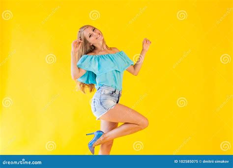 Beautiful Blonde With Blue Eyes Posing On A Yellow Background Stock