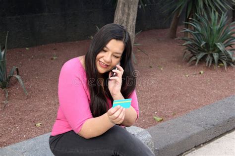 40 Year Old Latina Woman Uses Her Credit Card And Cell Phone To Make Purchases And Payments