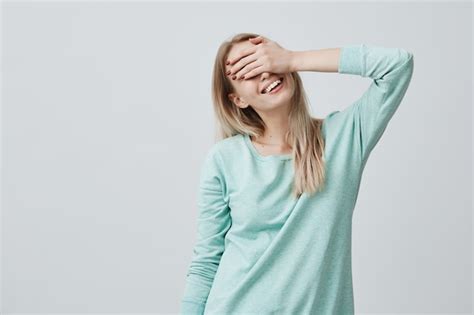 Feliz Mujer Con Cabello Rubio Cerrando Los Ojos Con La Mano Foto Gratis