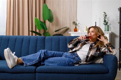 Premium Photo Mature Saucasian Woman Lying On Sofa And Drinking Red Wine