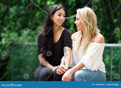 A Pair Of Proud Lesbian In Outdoors Looking At Each Other In A Garden Background Stock Image
