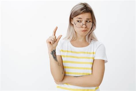 Incertain Fille Blonde Douteuse Avec Des Lunettes Posant Dans Le Studio Photo Gratuite