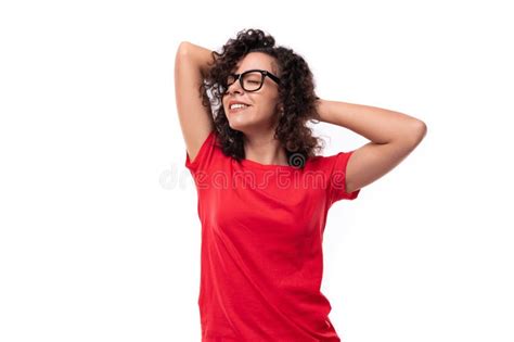 Una Joven Mujer De Brunette Ondulada Y Rizada En Un Camisa Roja En Un Fondo Con Un Espacio De