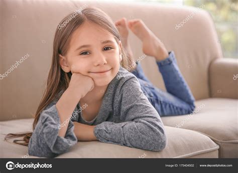 Petite Fille Mignonne Allongée Sur Canapé Maison Photo de stock par