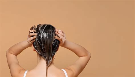 Premium Photo Young Woman Applying Hair Mask On Beige Background Back