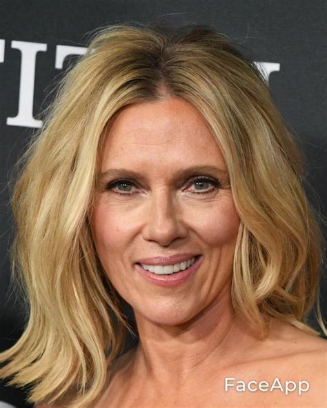 A Woman With Blonde Hair Smiling At The Camera