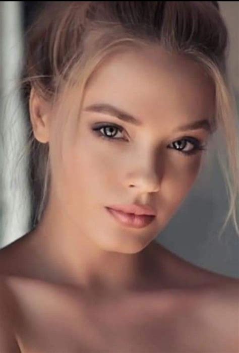 A Close Up Of A Woman With Very Big Eyes And Blonde Hair Wearing Black Bra