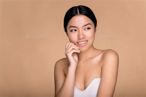 Attractive Brunette Asian Chinese Girl With Perfect Skin Posing At Isolated Beige Background