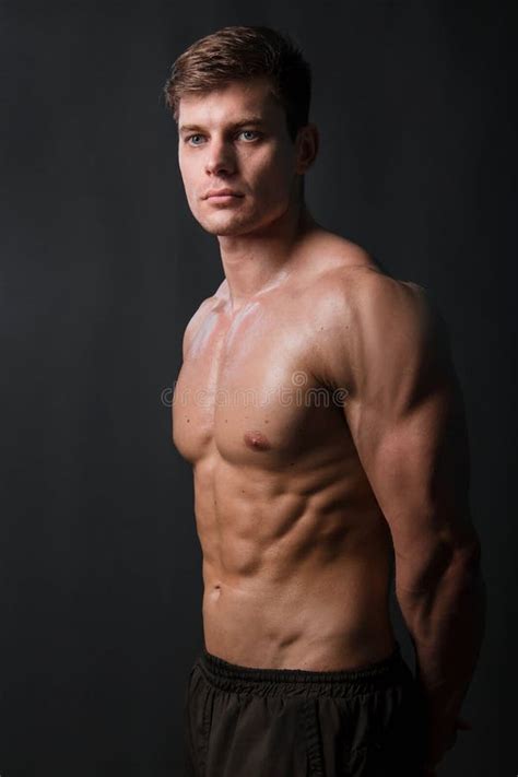 Muscular Bodybuilder Posing With A Naked Torso Against A Black Background Stock Photo Image