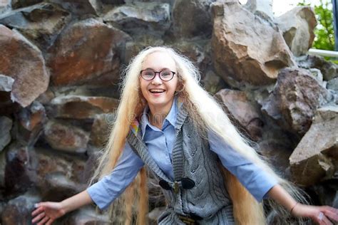 Pretty Teenage Girl Year Old With Curly Long Blonde Hair Near Stouns In The Green Park In