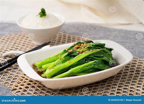 Xiao Bai Cai With Garlic Oyster Sauce With Chopsticks Served In Dish