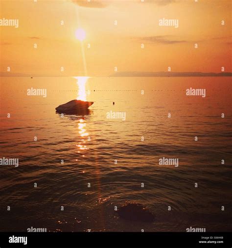 Sunset at sea with silhouette of speed boat Stock Photo - Alamy