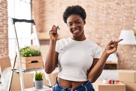 African American Woman Holding Keys Of New Home Smiling Happy Pointing