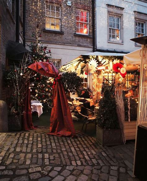 An Outdoor Market With Christmas Decorations And Lights On The Side Of