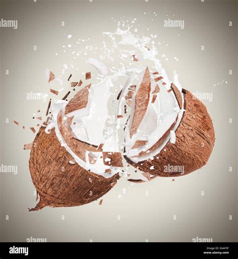 Coconut in motion with breaking pieces Stock Photo - Alamy